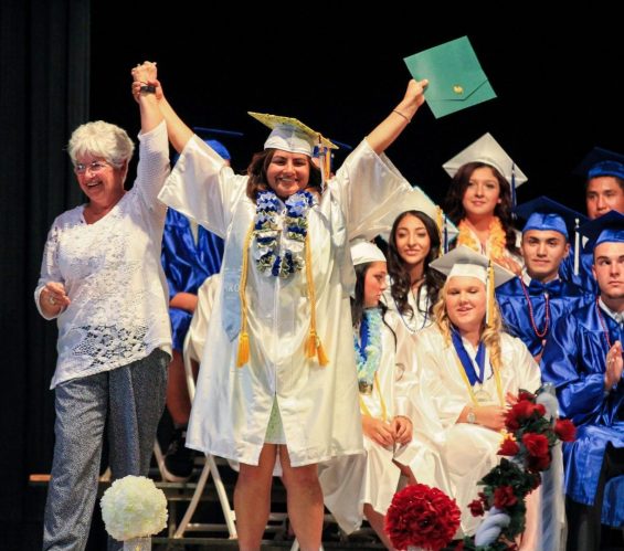 Person wearing cap and gown celebrating