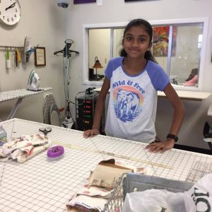 Child standing behind craft supplies