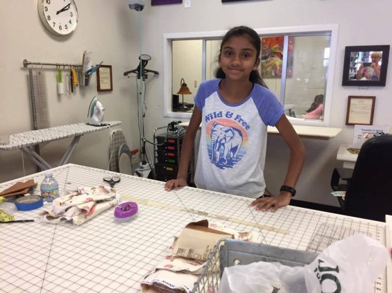 Child standing behind craft supplies