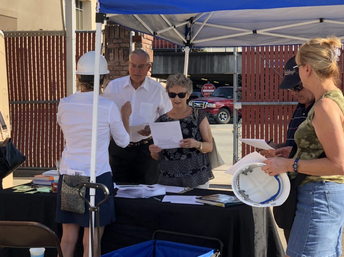 People under tent looking at paperwork