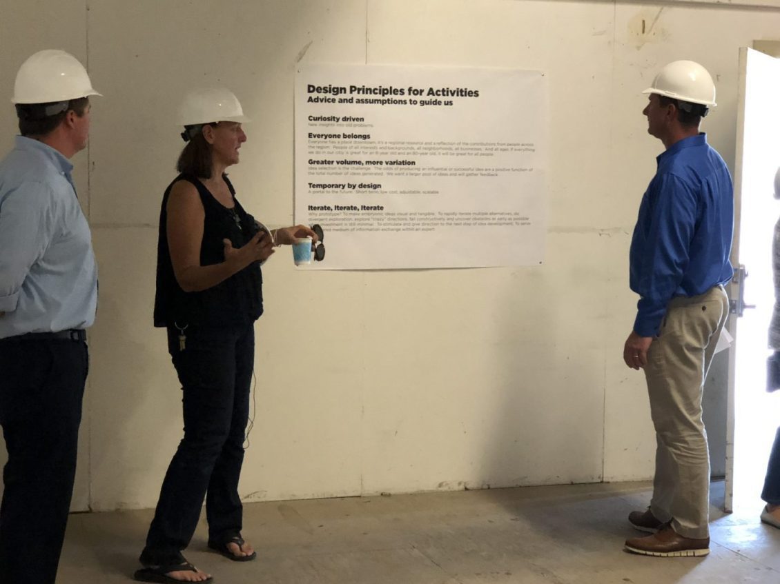 People in hard hats looking at sign