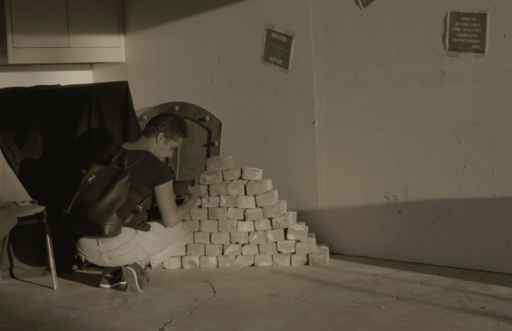Person next to stack of bricks
