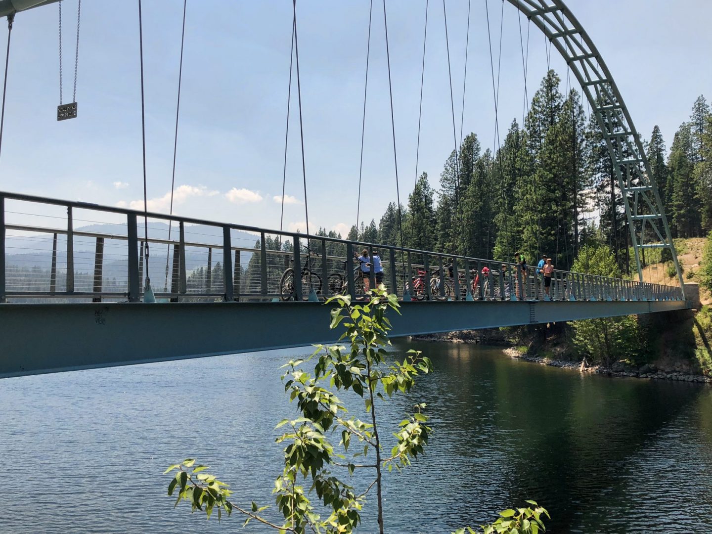 People biking and walking on bridge