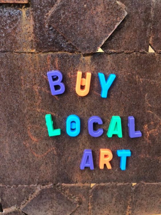Magnets spelling out buy local art on sheet metal